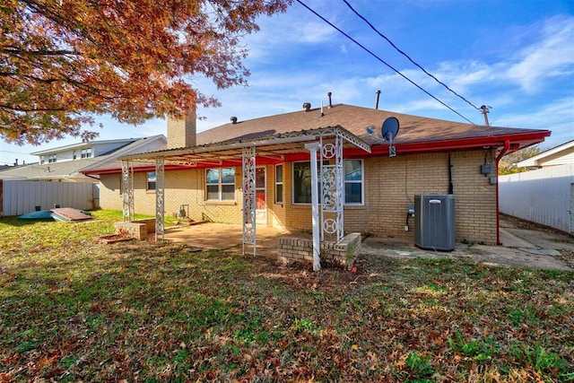 rear view of property with a yard, cooling unit, and a patio area