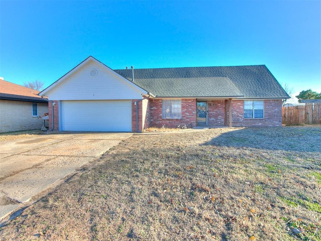 single story home with a garage and a front lawn