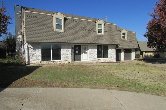 back of house featuring a yard and a garage