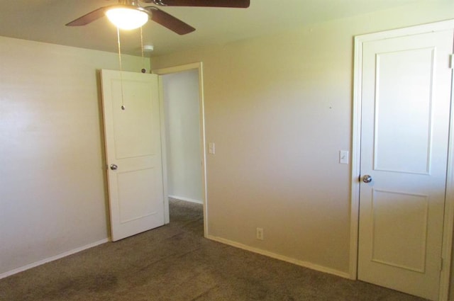 unfurnished bedroom with ceiling fan and dark colored carpet