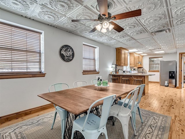 dining area featuring light wood-type flooring and ceiling fan