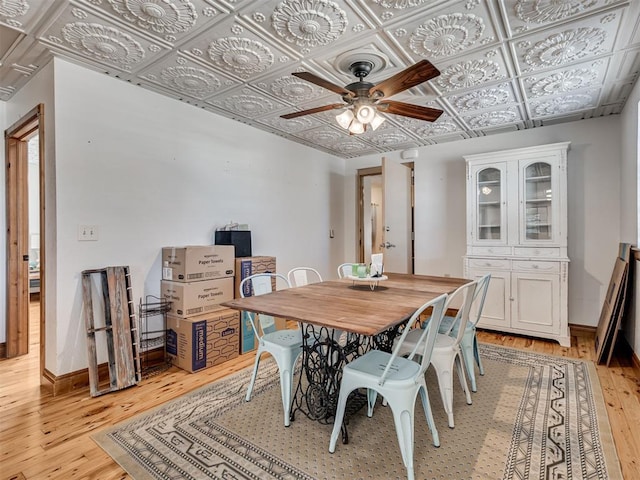 dining area with light hardwood / wood-style flooring and ceiling fan