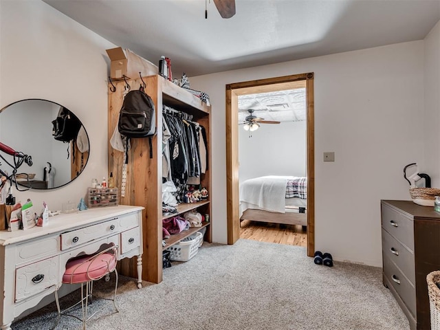 walk in closet with ceiling fan and light carpet