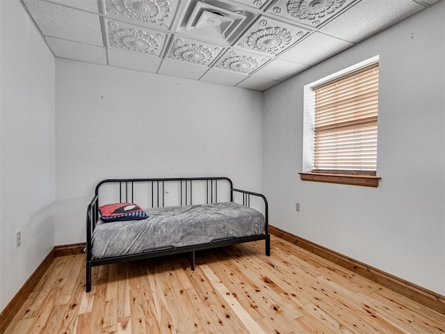 bedroom with hardwood / wood-style flooring and a paneled ceiling