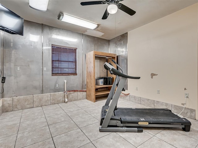 exercise room featuring ceiling fan and light tile patterned flooring