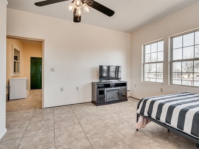 bedroom featuring ceiling fan, light tile patterned flooring, and white refrigerator