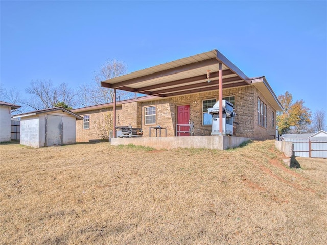 rear view of house with a patio, a storage shed, and a lawn