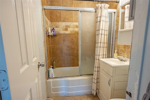 bathroom with combined bath / shower with glass door, vanity, and tile patterned flooring