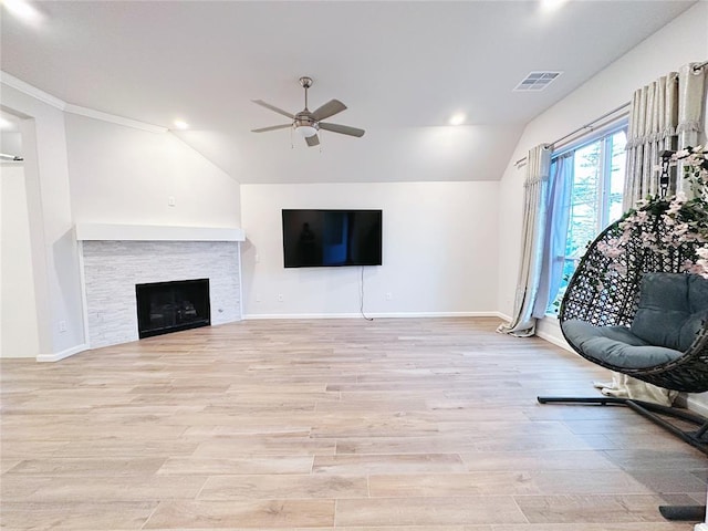 unfurnished living room featuring ceiling fan, light wood-type flooring, ornamental molding, and vaulted ceiling