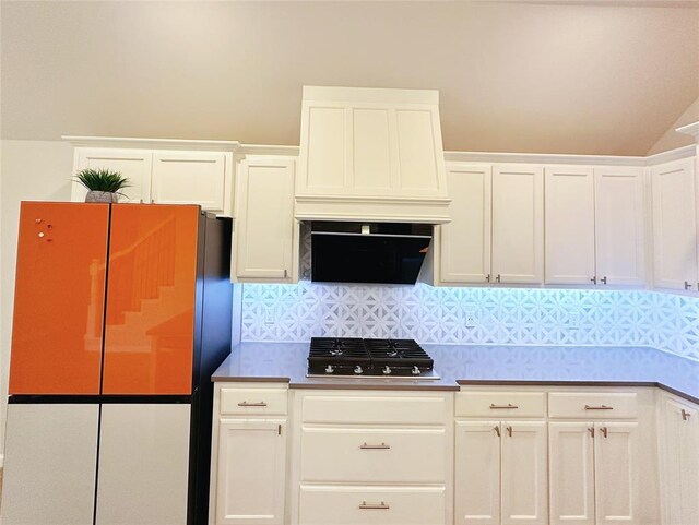 kitchen featuring gas cooktop, backsplash, premium range hood, stainless steel fridge, and white cabinets