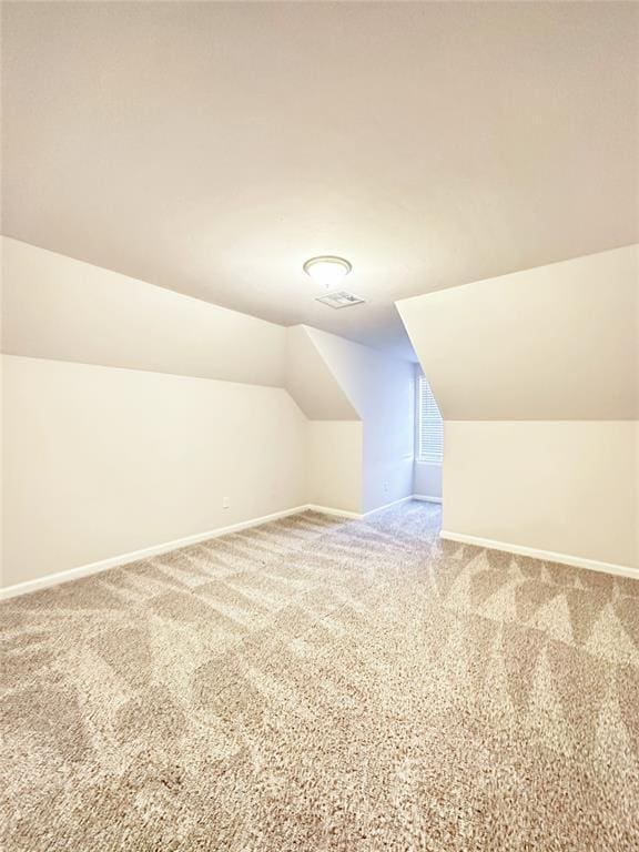 bonus room with lofted ceiling and carpet floors