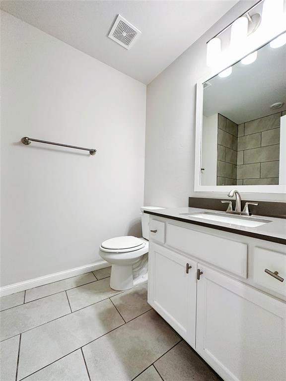 bathroom featuring tile patterned floors, vanity, and toilet