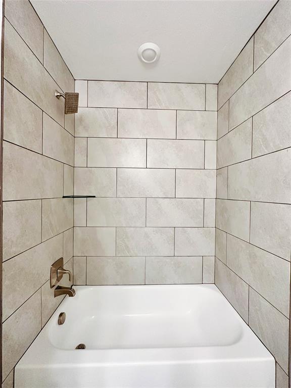 bathroom with tiled shower / bath combo