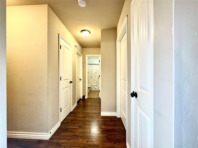 hall with dark wood finished floors and baseboards