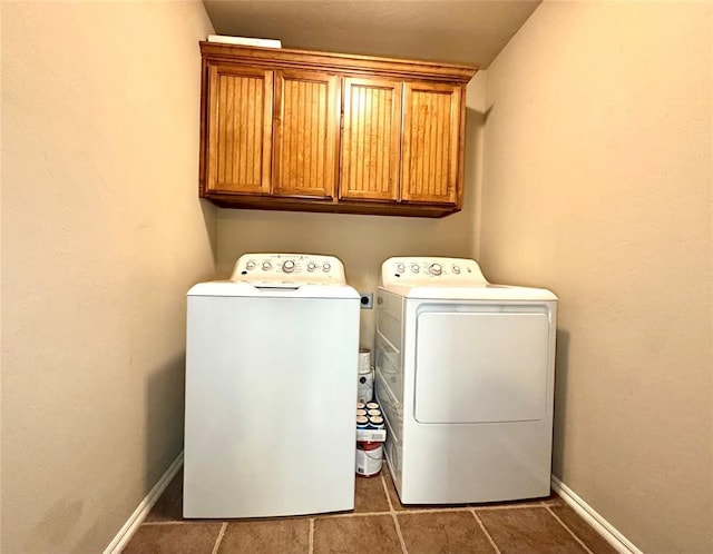 laundry area with baseboards, cabinet space, and washing machine and dryer