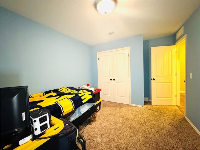 carpeted bedroom with a closet, visible vents, and baseboards