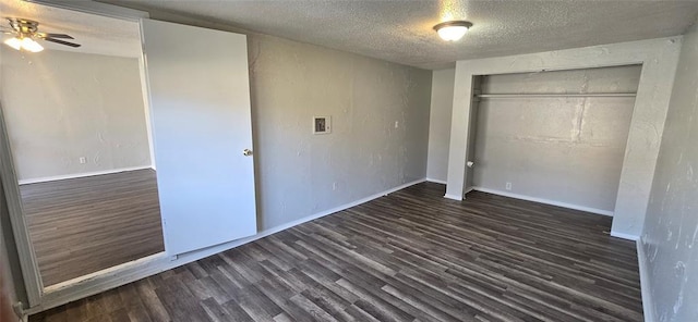 unfurnished bedroom featuring a textured ceiling, a closet, and dark wood-type flooring