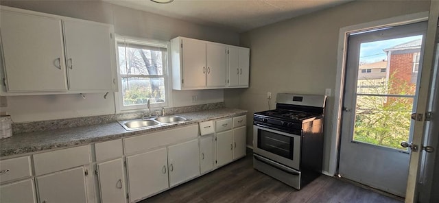 kitchen featuring a wealth of natural light, white cabinetry, stainless steel range with gas stovetop, and sink