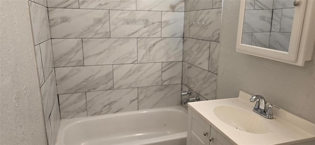 bathroom featuring tiled shower / bath combo and vanity