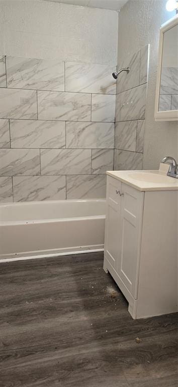 bathroom featuring tiled shower / bath, hardwood / wood-style floors, and vanity