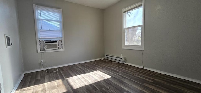 empty room featuring baseboard heating, dark wood-type flooring, plenty of natural light, and cooling unit