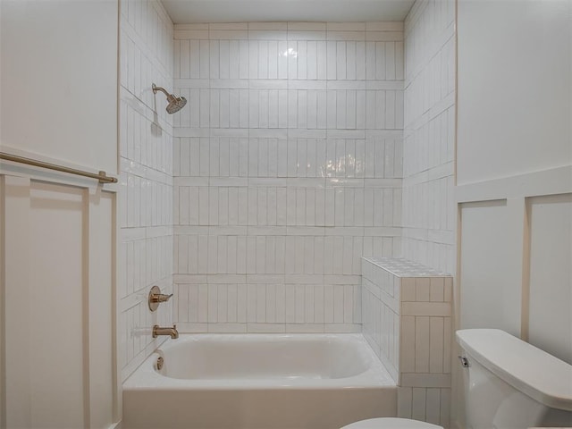 bathroom with toilet and tiled shower / bath