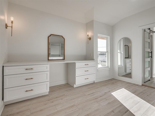 bathroom with wood-type flooring and vaulted ceiling