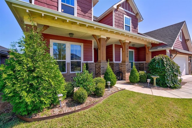 craftsman-style house with covered porch, a garage, and a front yard