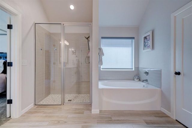 bathroom featuring plus walk in shower, hardwood / wood-style floors, and lofted ceiling