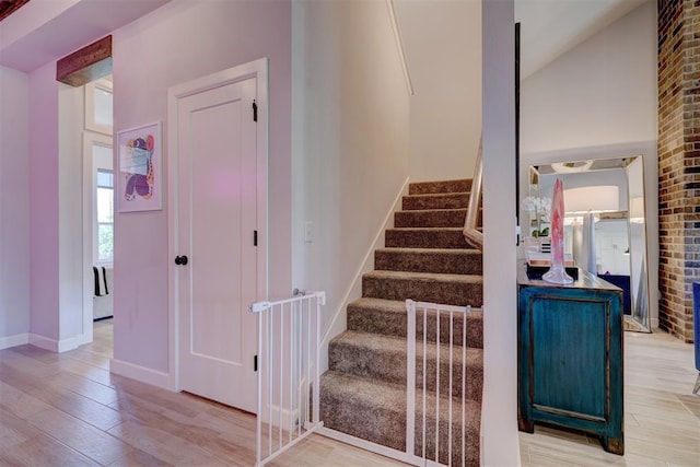 stairs featuring hardwood / wood-style floors and lofted ceiling