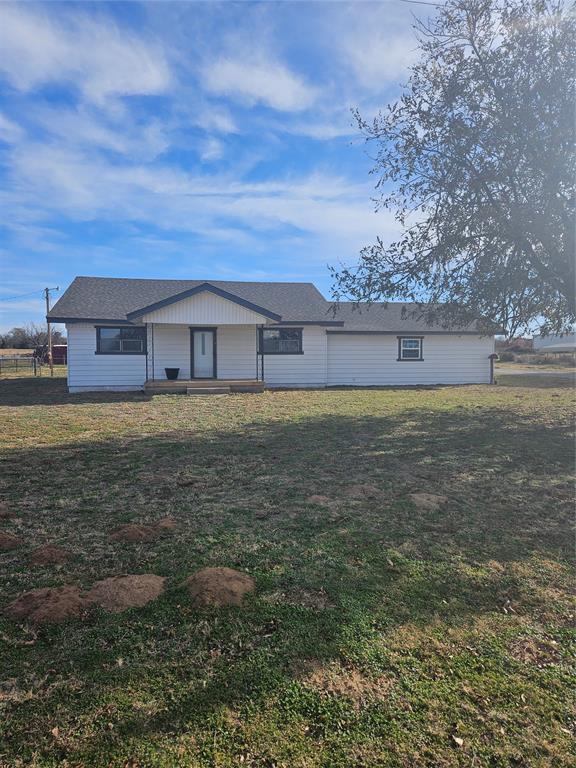 back of property featuring a lawn