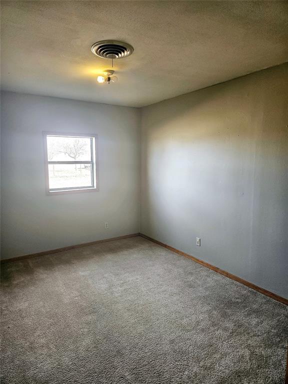 carpeted spare room featuring a textured ceiling