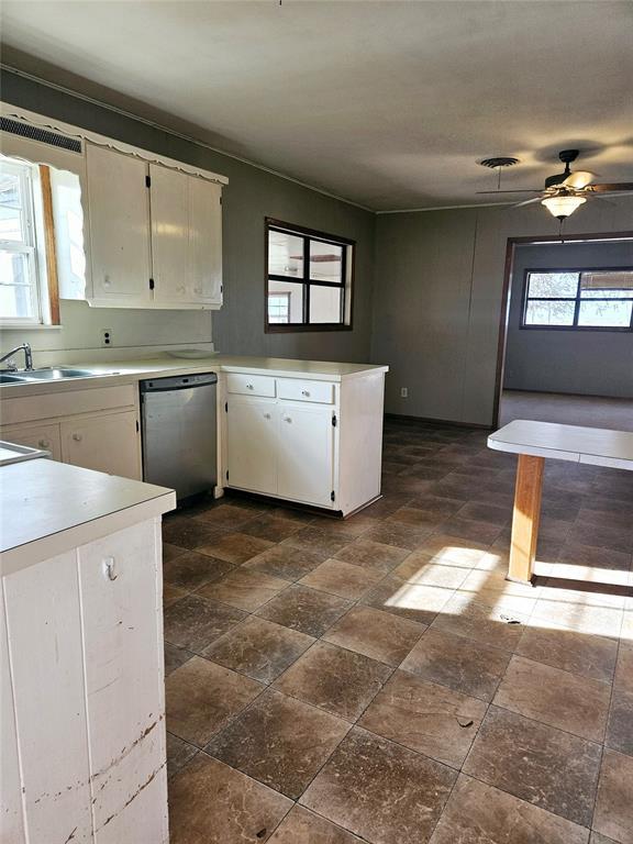 kitchen with white cabinets, sink, stainless steel dishwasher, ceiling fan, and kitchen peninsula