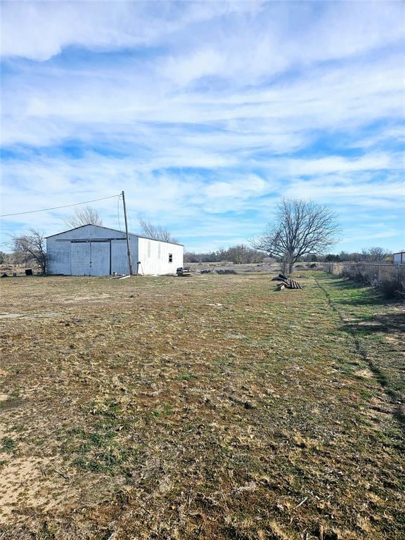 view of yard featuring a rural view and an outdoor structure