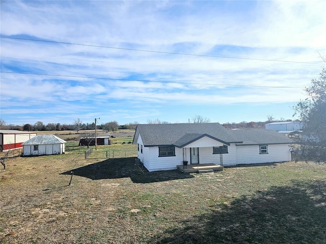 view of front of house with an outdoor structure and a front yard