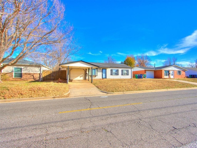 ranch-style home with a front yard, a garage, and a carport