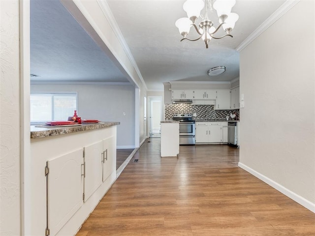 hallway with crown molding, hardwood / wood-style floors, and an inviting chandelier