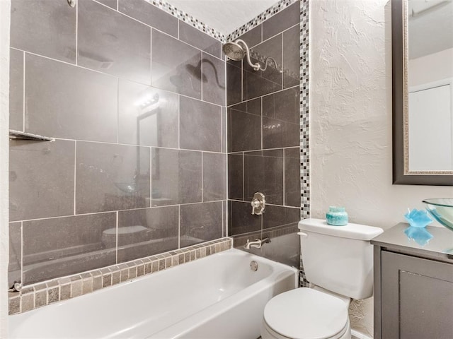 full bathroom with vanity, tiled shower / bath combo, and toilet