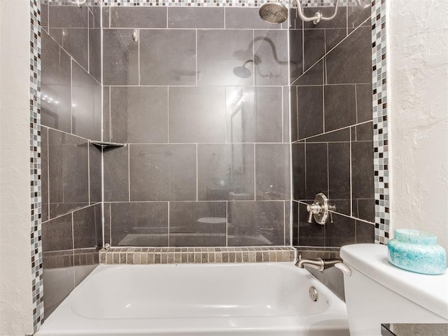 bathroom featuring toilet and tiled shower / bath