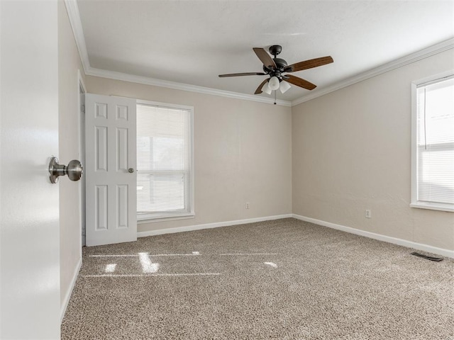 carpeted empty room with ceiling fan and crown molding