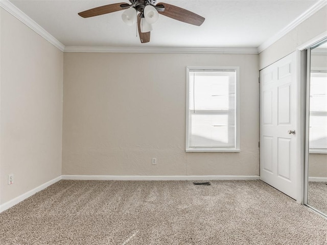 carpeted empty room featuring crown molding and ceiling fan