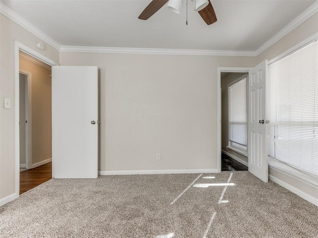 carpeted empty room featuring ceiling fan and ornamental molding