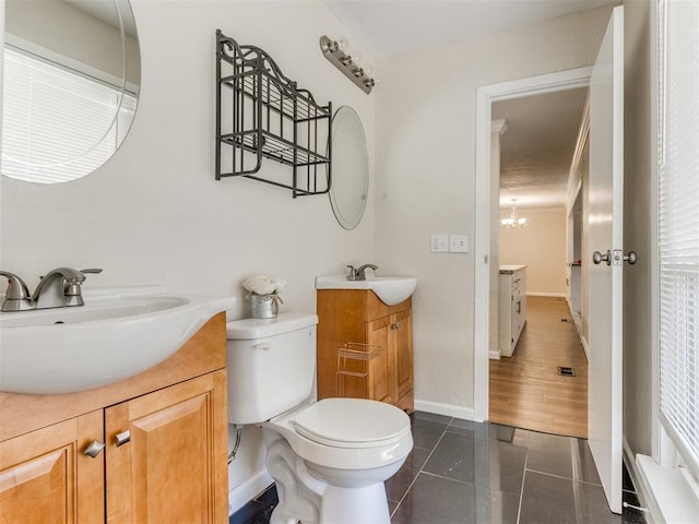 bathroom with toilet, tile patterned floors, vanity, and an inviting chandelier