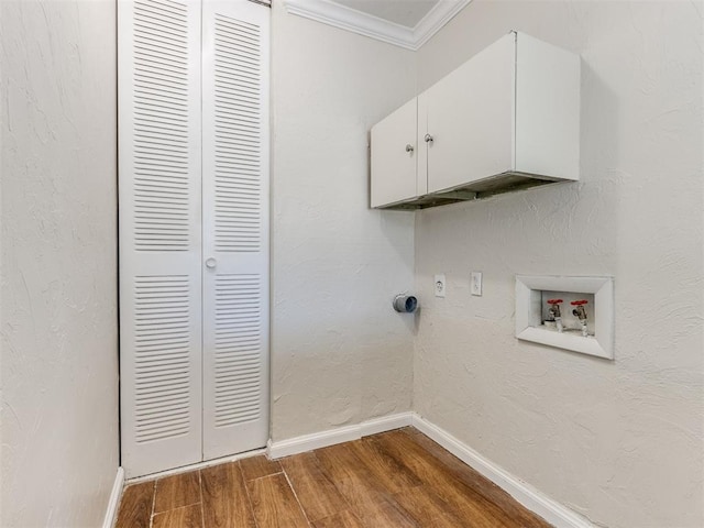 laundry room with hookup for a washing machine, crown molding, hardwood / wood-style floors, and cabinets