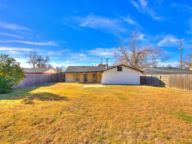 rear view of property with a lawn and a patio