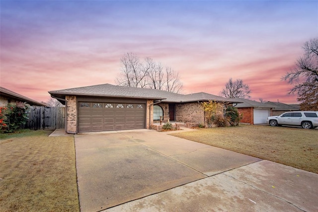 ranch-style home featuring a lawn and a garage