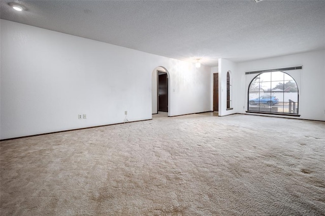 carpeted spare room featuring a textured ceiling