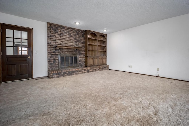 unfurnished living room featuring a fireplace, carpet, and a textured ceiling