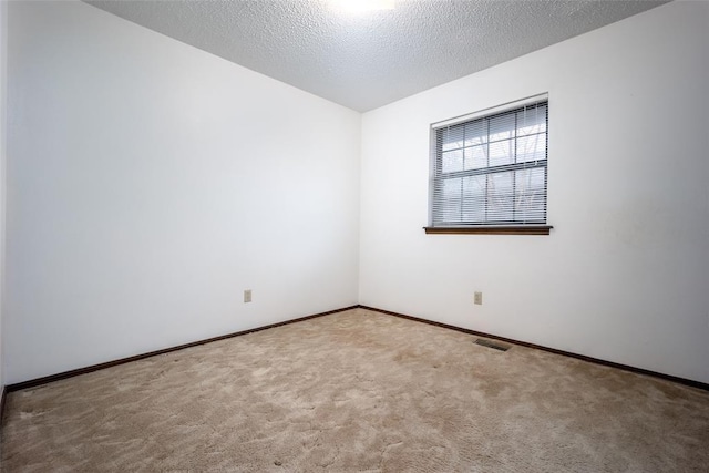 carpeted empty room featuring a textured ceiling