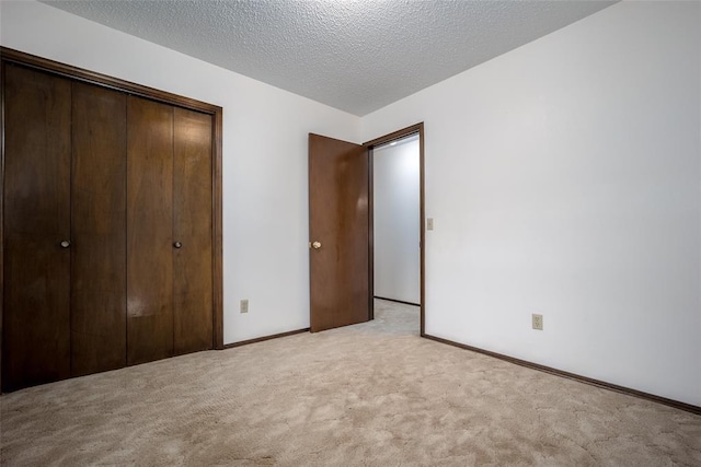 unfurnished bedroom featuring a closet, light colored carpet, and a textured ceiling